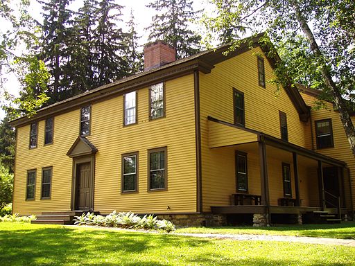 Yellow two story house with chimney in New England