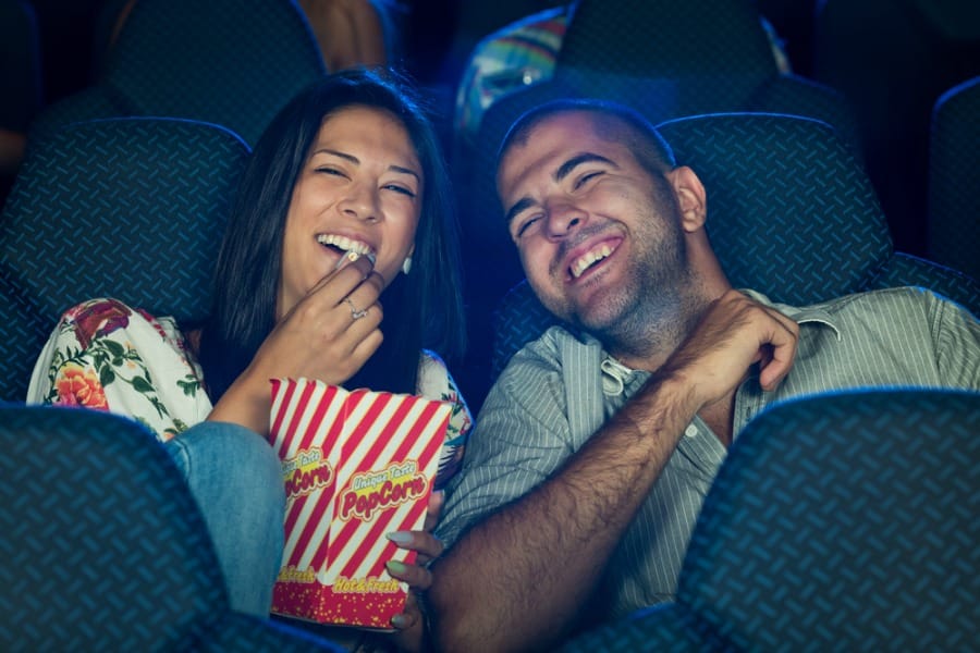 man and woman on a date at the movies with popcorn