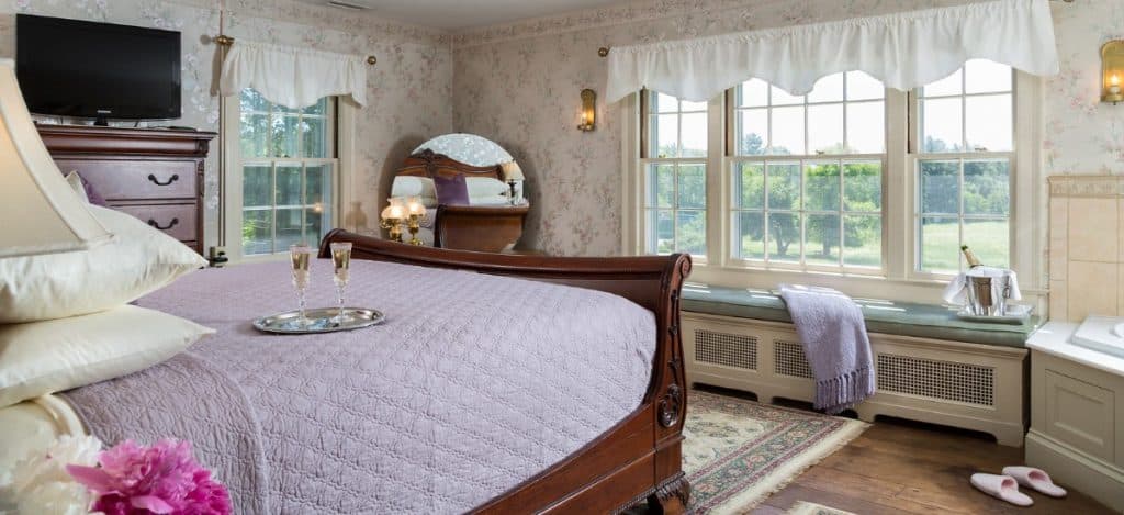 Spacious guest room with Champagne on the bed, window seat, and tub in the corner