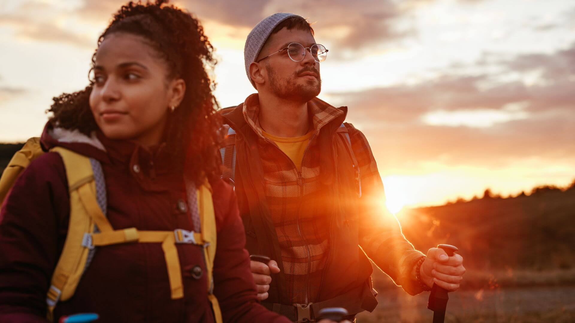 couple on a hike with the sunset in the background