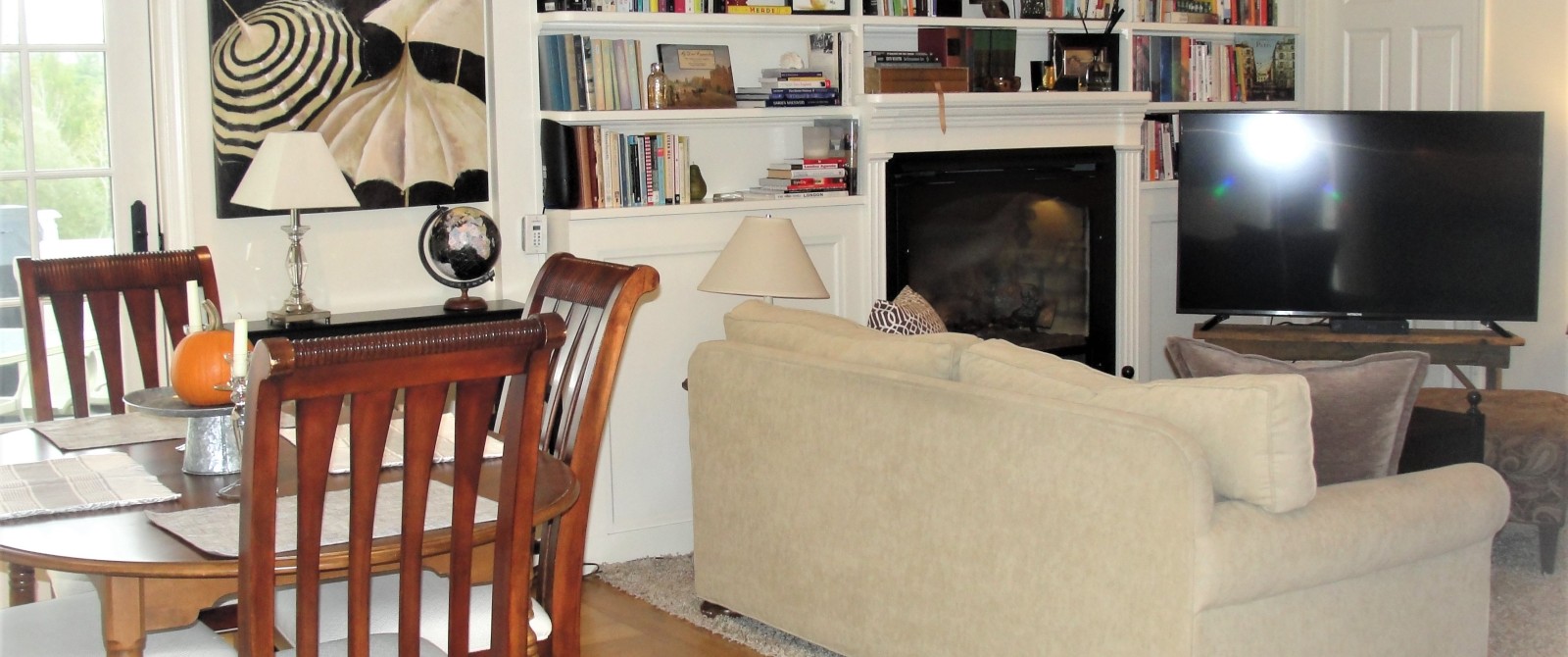 Wood dining table with cream couch next to it