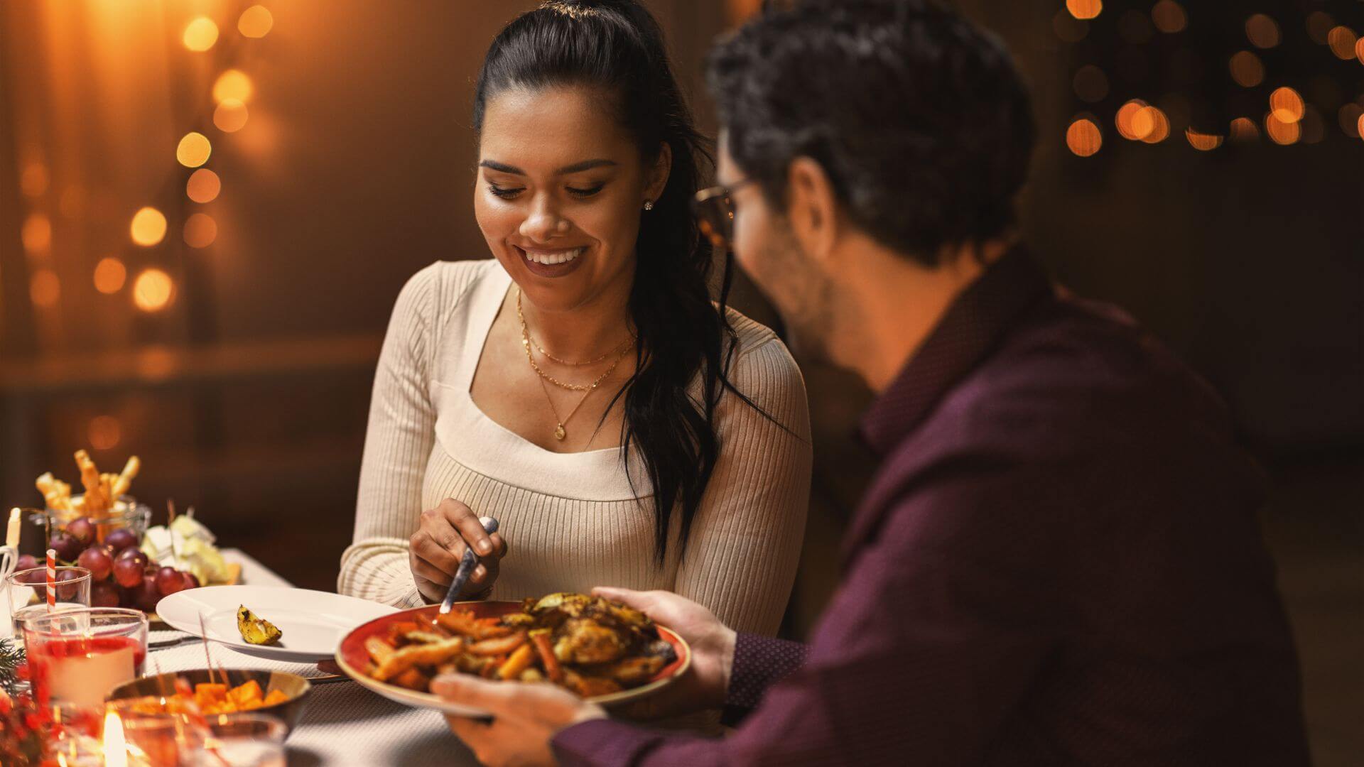 couple enjoying a cozy romantic dinner together at a warmly lit table
