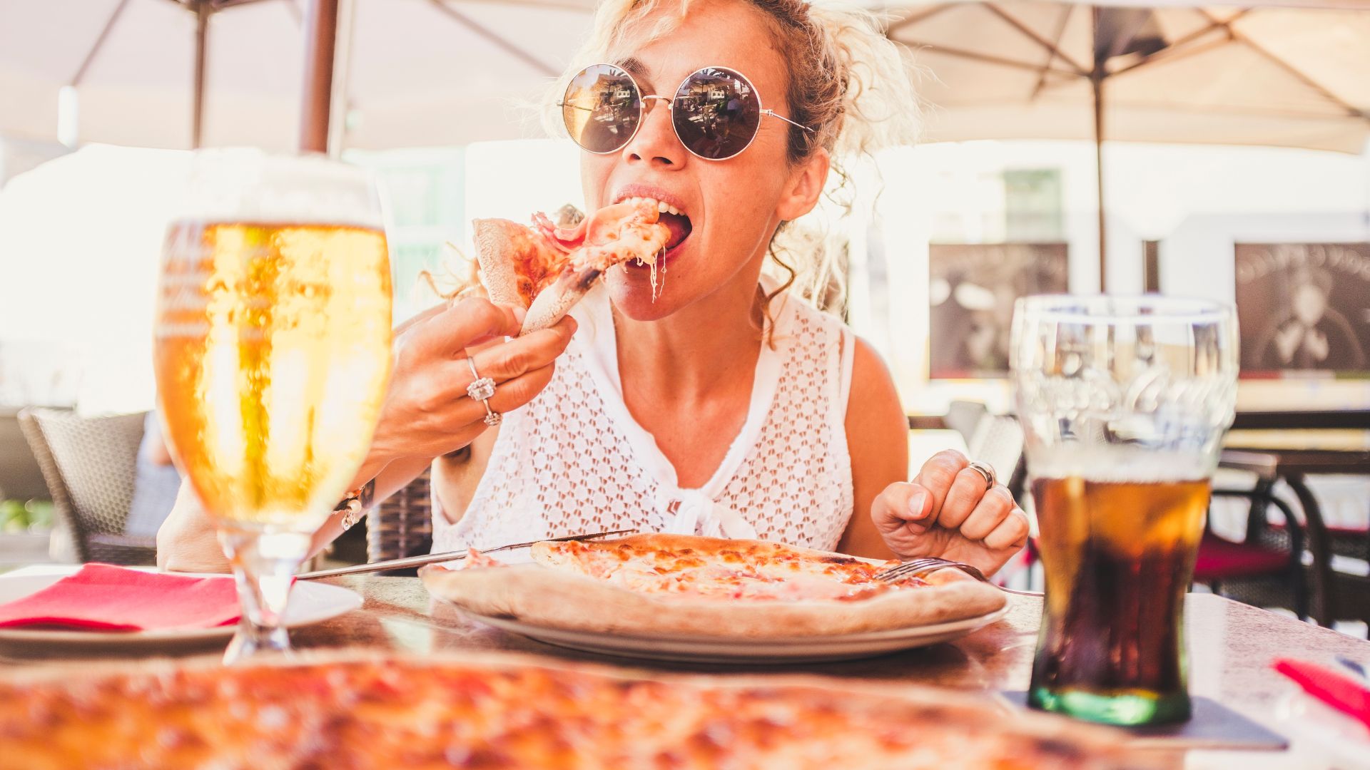 A woman at a casual dining restaurant eating a pizza