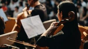 cellist with orchestra in blurred background