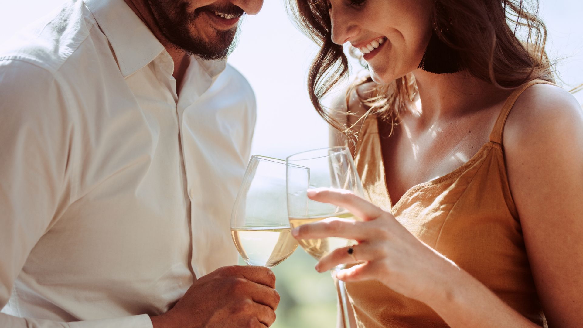 A couple drinking white wine and smiling