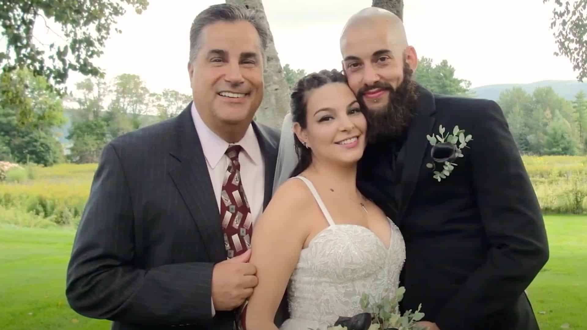 Doug Bagnasco posing as the officiant with a bridal couple