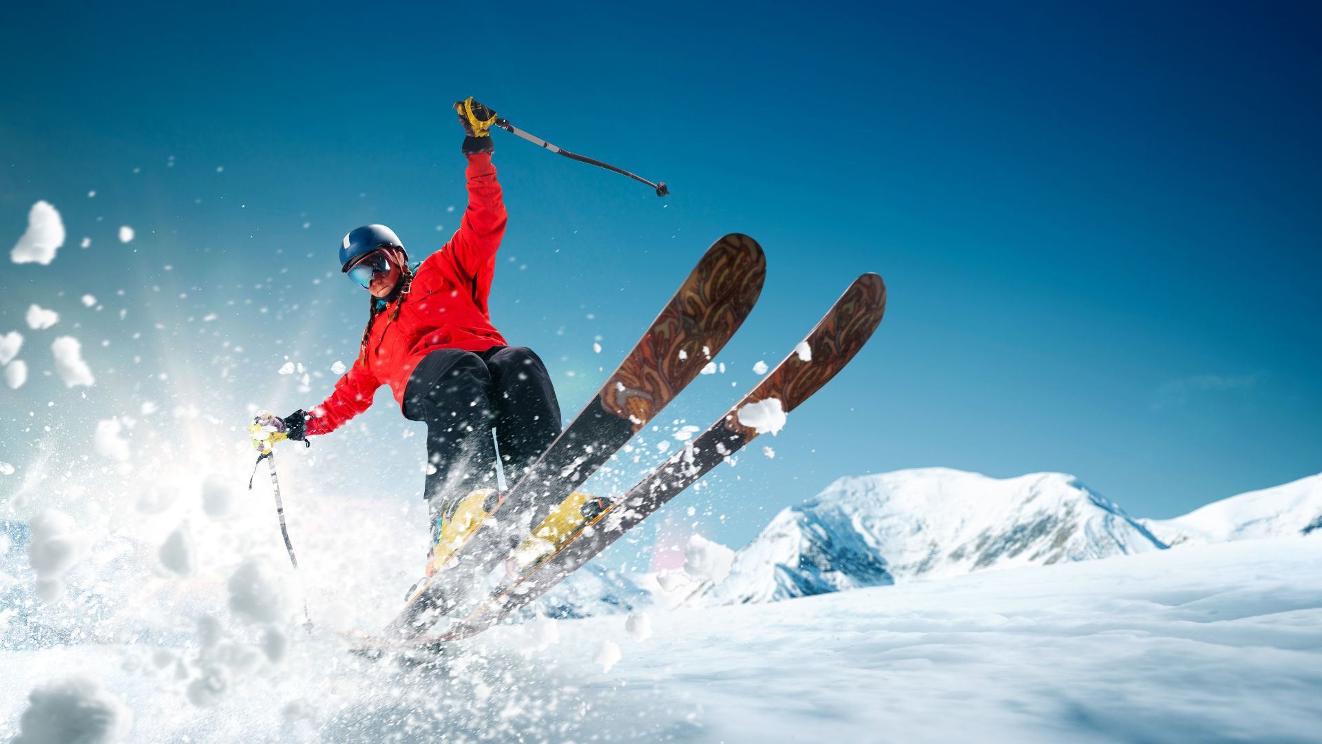 A downhill skier on the slopes with the sun shining brightly