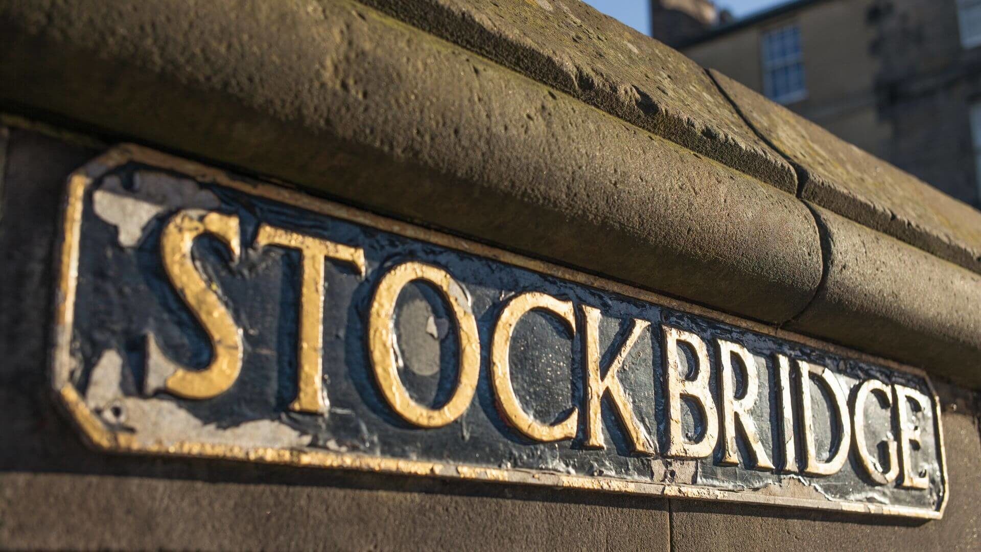 Stone sculpture with text Stockbridge marking entrance to city