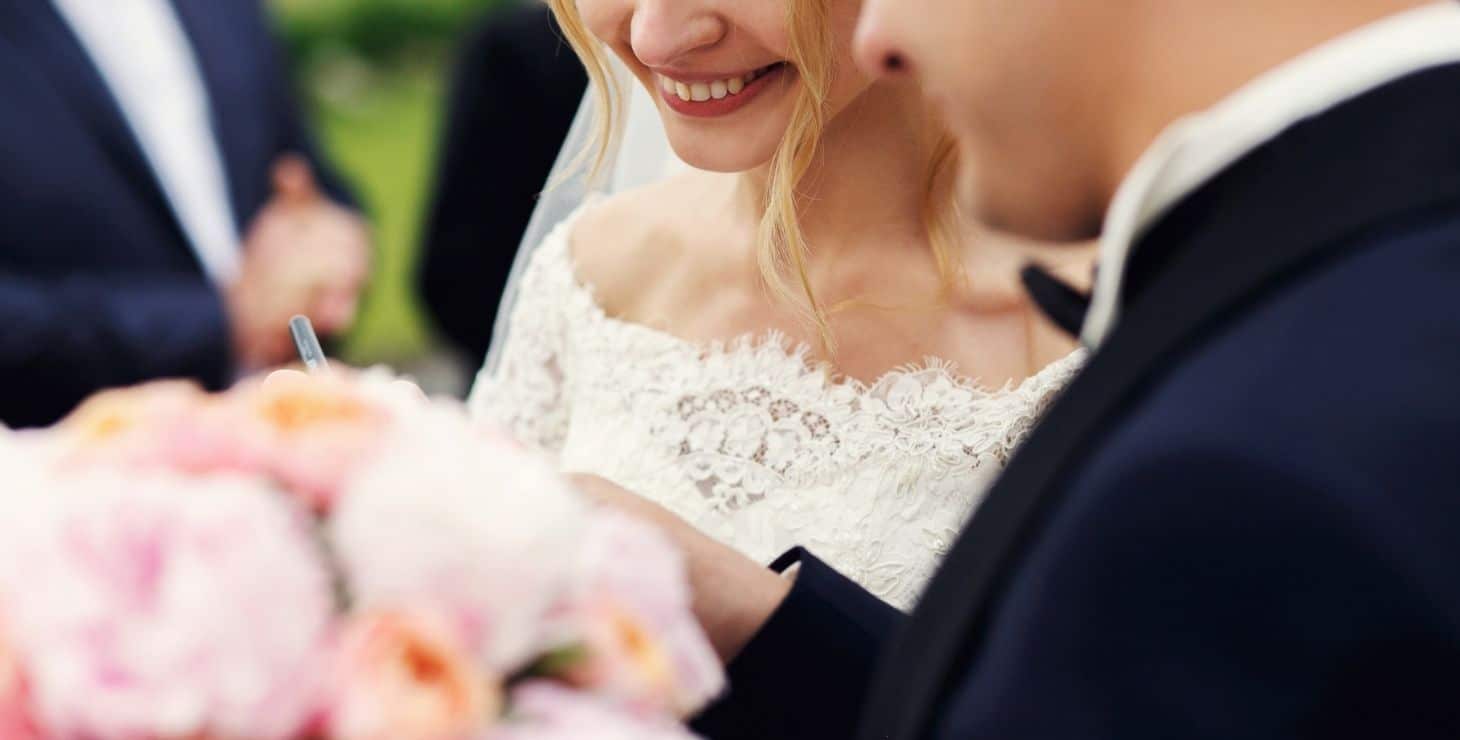 Bride and groom saying their vows with officiant in the background