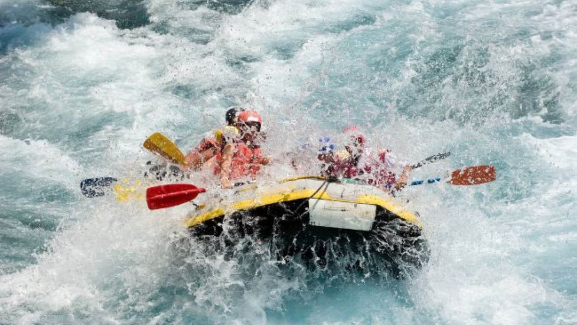 Group of people white-water rafting down rapids