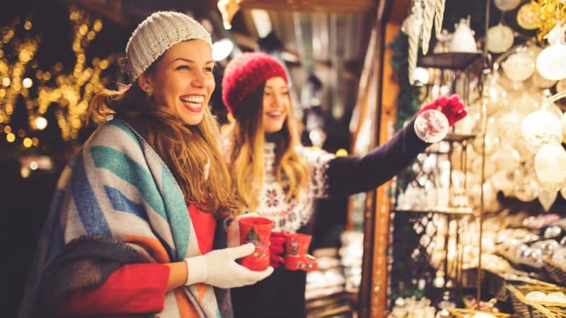 Two ladies shopping in a Christmas outdoor marketplace