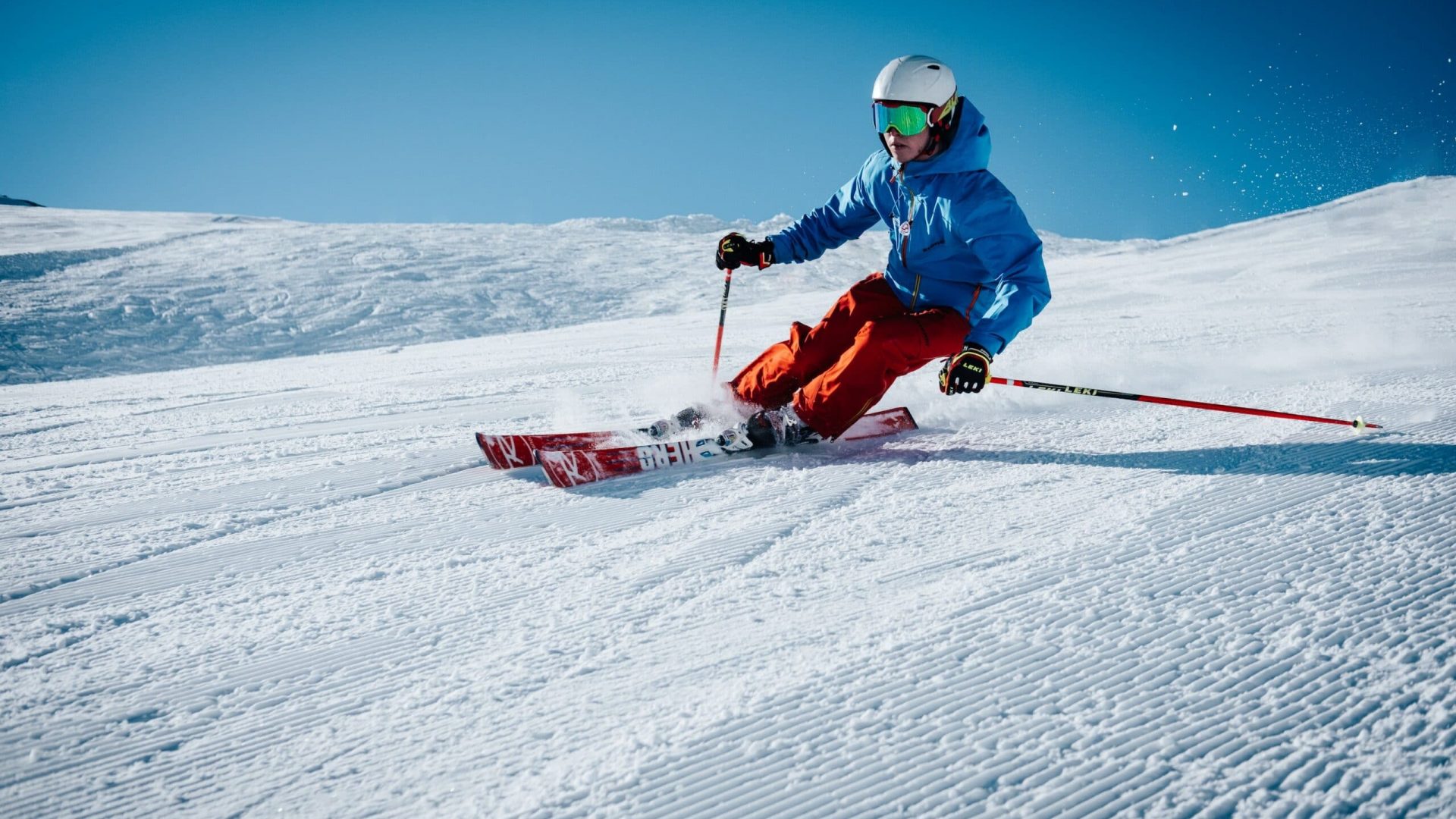 Person skiing downhill amidst blue skies