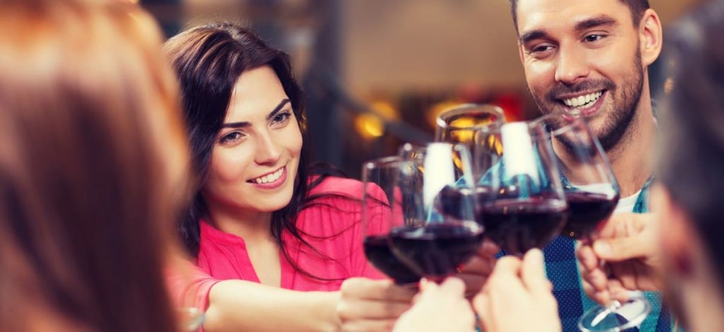 Friends out celebrating at local restaurant with red wine toast