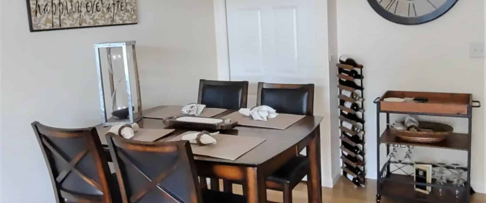 Dining area with wooden table and chairs, wine rack, and buffet cart