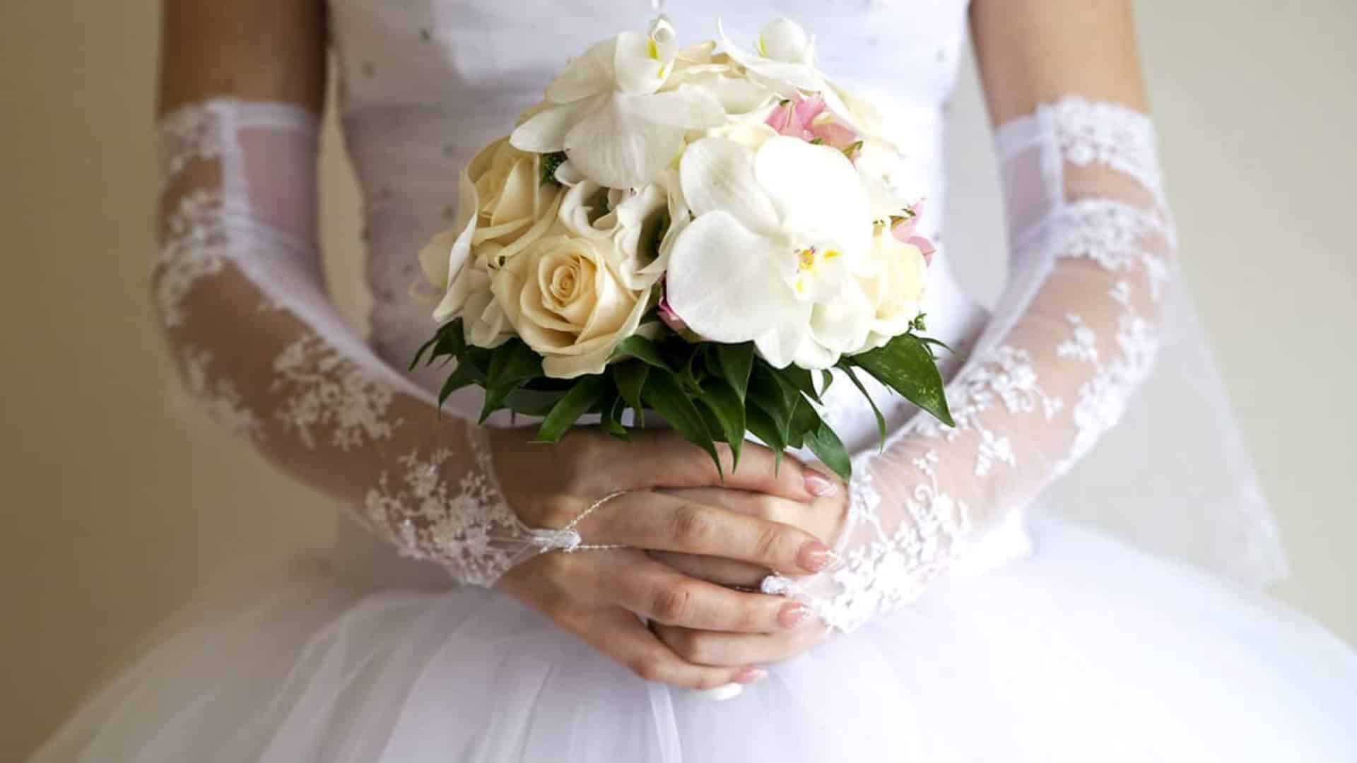 Woman in white dress holding a bouquet with white flowers