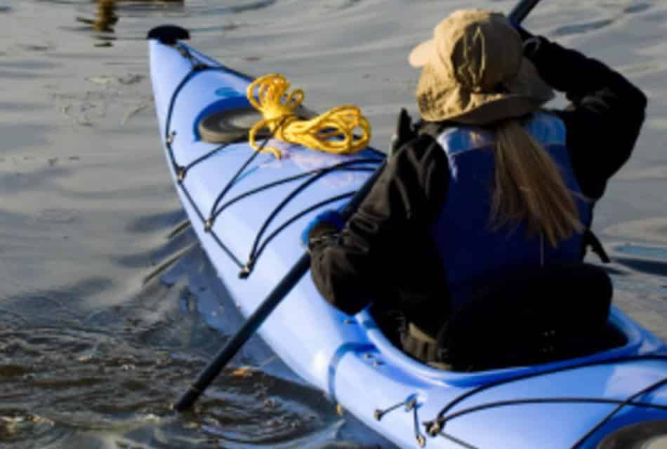 Woman kayaking in a blue kayak