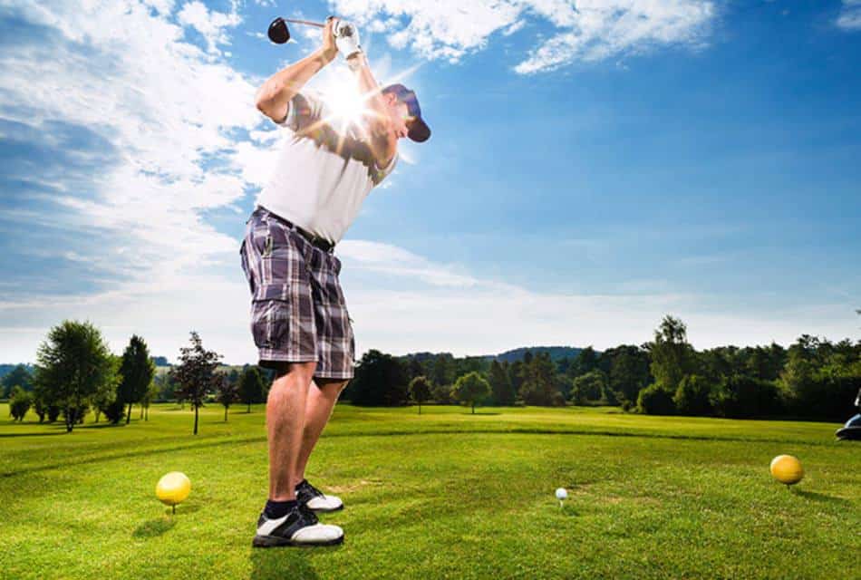 Man swinging a golf club from the tee