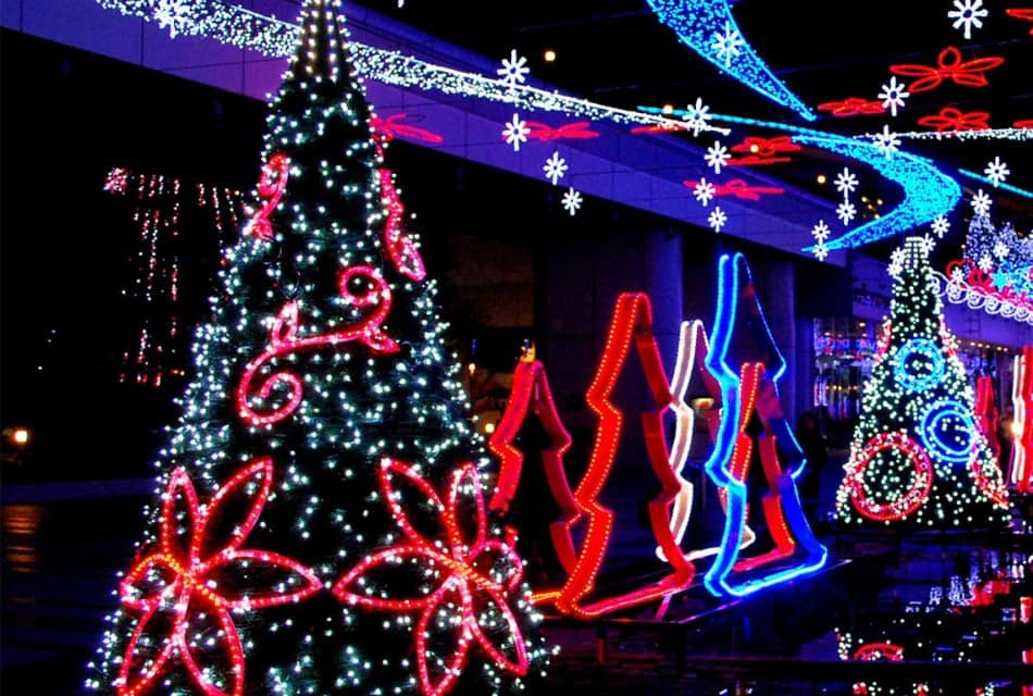 Christmas decorations at night covered in red, blue and white lights