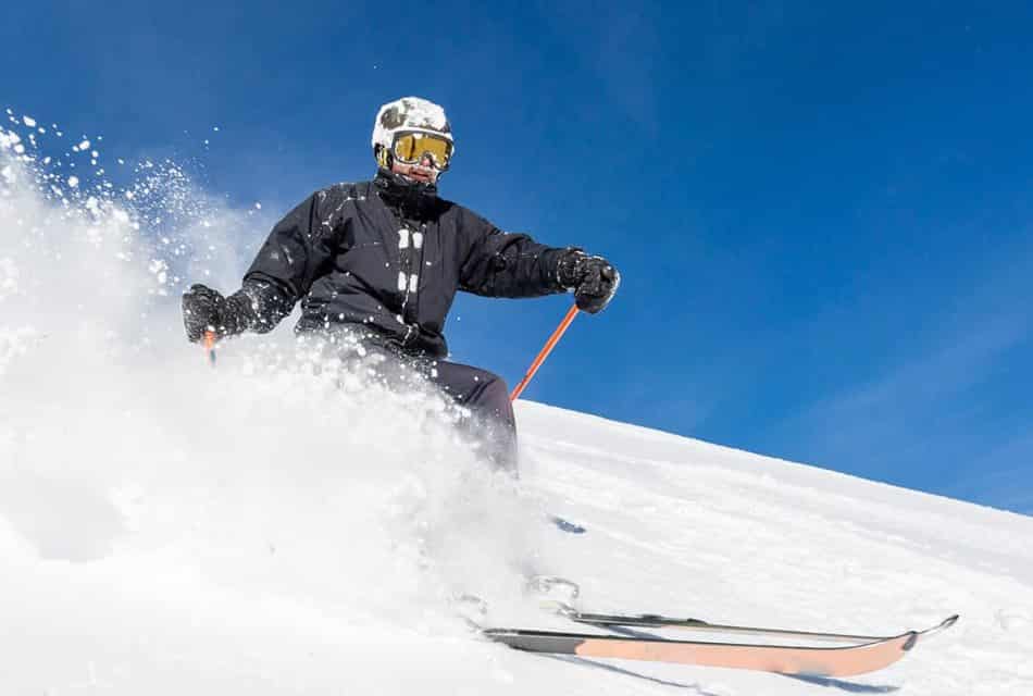 Man skiing downhill in lots of snow