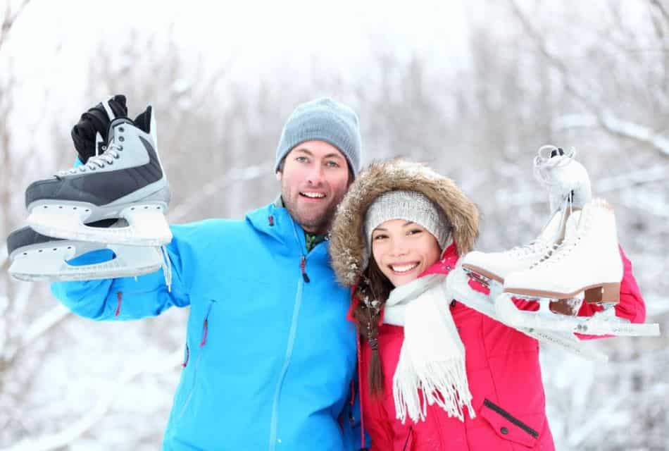 Man and woman holding ice skates